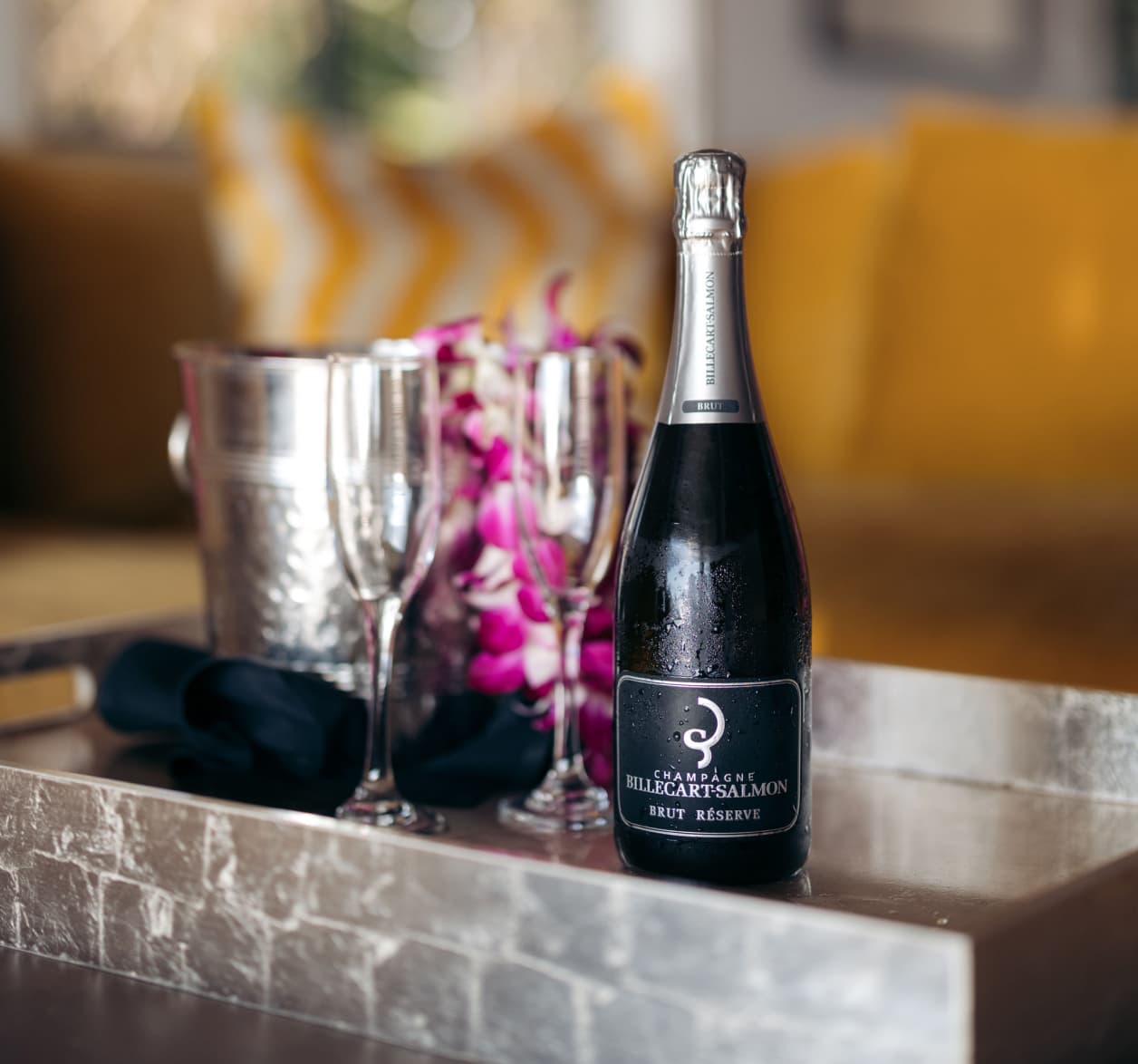 Billecart Salmon Brut Reserve Champagne with two glasses and lei