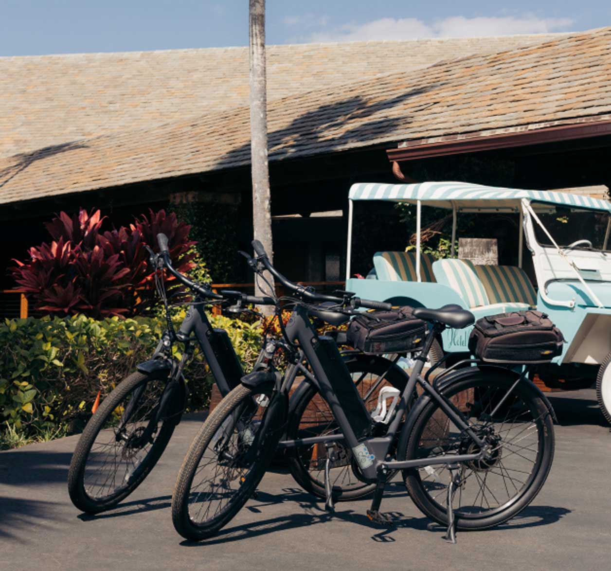 Two complimentary e-bikes parked next to each other on the front drive with the hotel entrance in the background.