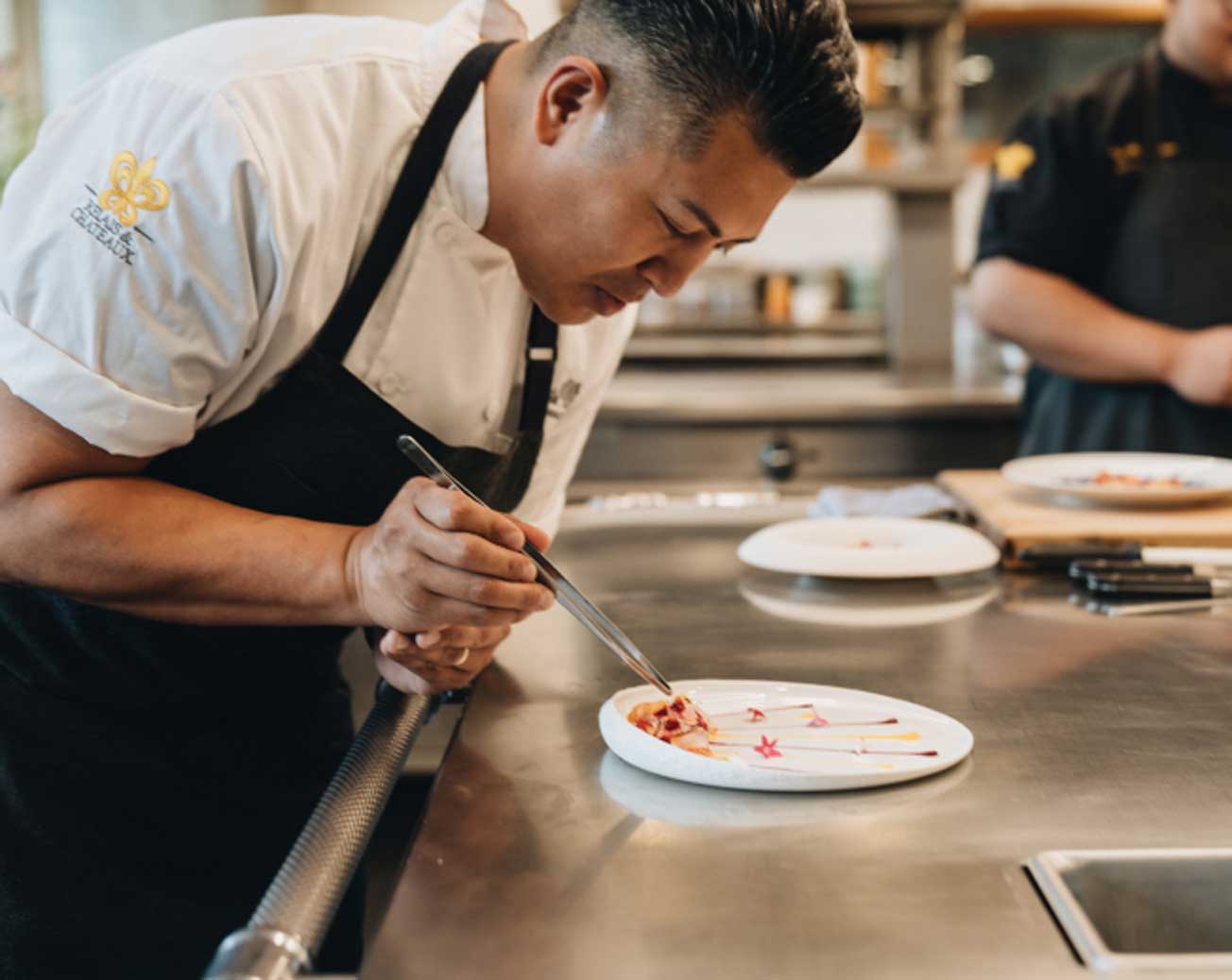 Chef Ryan Cruz Plating a Dish in The Kitchen at The Restaurant